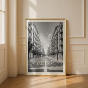 May include: Monochrome framed print depicting a street in Barcelona. The image shows a long road flanked by buildings. The text "BARCELONA SPAIN" is displayed at the bottom of the print.