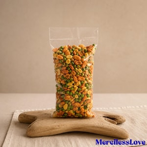 May include: A clear plastic bag filled with a savory snack mix containing green peas, orange-colored crunchy corn kernels, and tan-colored nuts. The bag is sealed at the top and stands upright, displaying a variety of textures and warm earth tones.
