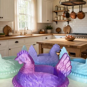 Puede incluir: Una colecci&oacute;n de recipientes de pl&aacute;stico con forma de gallina, coloridos, en un entorno de cocina. Las gallinas son de tonos morados, azules y verdes. Los recipientes tienen un dise&ntilde;o similar a una cesta y probablemente se utilizan para almacenamiento o decoraci&oacute;n.