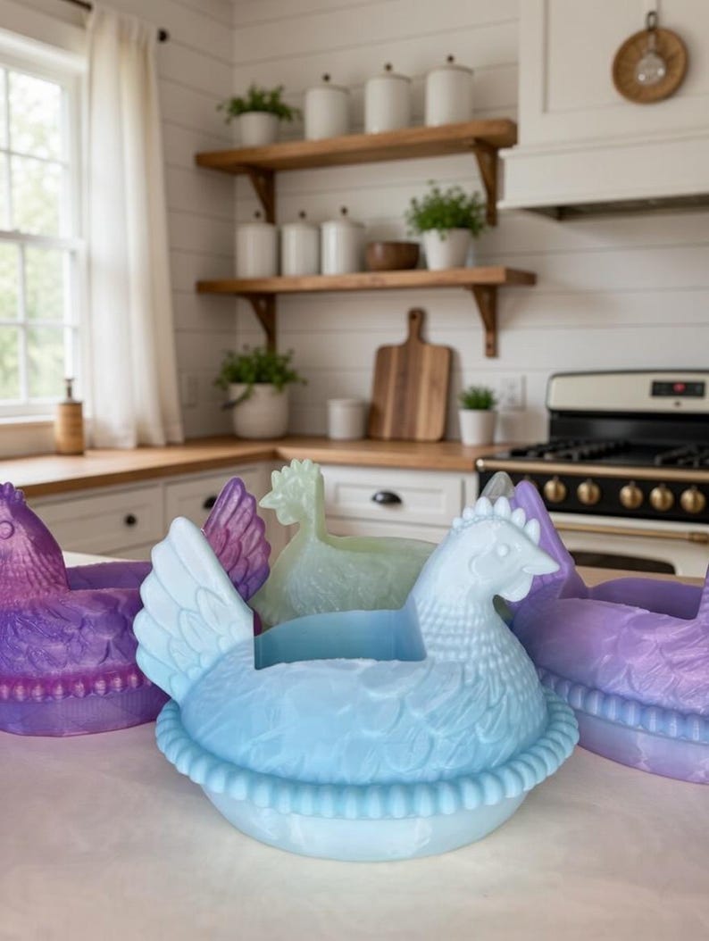 Puede incluir: Una colecci&oacute;n de recipientes con forma de gallina en tonos azul, morado y verde. Los recipientes est&aacute;n dise&ntilde;ados con detalles de plumas y nidos, perfectos para la decoraci&oacute;n de la cocina o exhibiciones de Pascua.