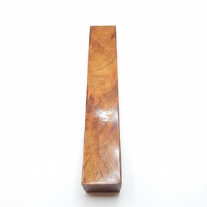 May include: A rectangular wooden object with a polished, glossy finish. The wood grain is visible, displaying a mix of light and dark brown tones. The object is standing upright against a white background.