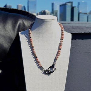 May include: A white ceramic mug with a black handle and the text "But First, Coffee" in a black, bold font. The mug is on a white surface.