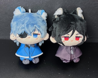 Può includere: Due bambole di peluche con caratteristiche in stile anime. Una bambola ha i capelli blu, un abito blu e una benda sull'occhio. L'altra bambola ha i capelli neri e un abito viola. Entrambe le bambole hanno orecchie di animali e tratti del viso ricamati.
