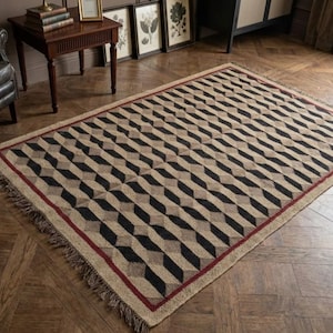 Könnte beinhalten: Rechteckiger Teppich mit geometrischem Muster. Der Teppich hat ein sich wiederholendes Design aus schwarzen und beigen Formen, mit einem dünnen roten Rand und Fransen. Er liegt auf einem Holzboden.