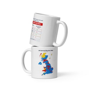 May include: Two white ceramic mugs, one stacked on the other. The top mug displays text and a chart about a Labour victory. The bottom mug features a map of the UK with coloured regions and the text "UK General Election 1964".