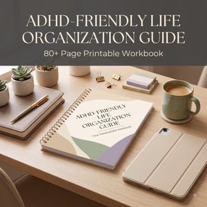 Peut inclure: Un cahier à spirales intitulé ADHD-FRIENDLY LIFE ORGANIZATION GUIDE: Your Personalized Workbook, avec des formes abstraites beiges, vertes et violettes sur la couverture, accompagné d'un stylo doré, d'une tablette, d'une tasse et de petites plantes.