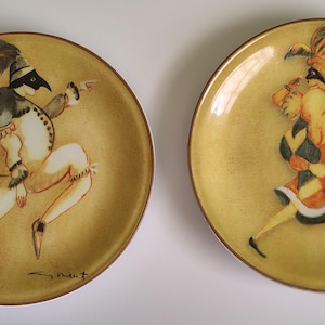 Puede incluir: Una taza de cerámica blanca con un asa negra y el texto "But First, Coffee" en negrita negra. La taza está sobre una superficie de madera. La taza mide aproximadamente 10 cm de alto.