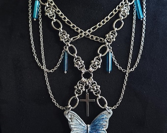 Collar gótico de capas hecho a mano con mariposa azul esculpida y cruz, gargantilla artesanal llamativa, acero inoxidable, estética oscura.