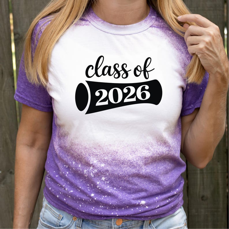 May include: White and purple tie-dye t-shirt with the text "class of 2026" in black. The shirt has a crew neck and short sleeves. The design is centered on the front of the shirt.