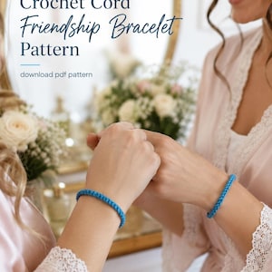 May include: Image of a blue crochet cord friendship bracelet. The image also includes the text "Crochet Cord Friendship Bracelet Pattern" and "download pdf pattern". The bracelet is worn on a wrist.