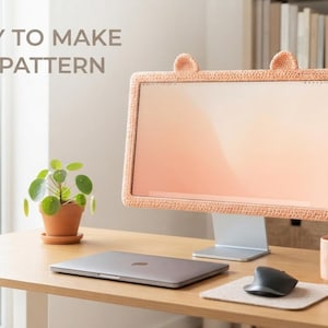 Puede incluir: Una funda para marco de monitor hecha de hilo de ganchillo color melocotón, con dos pequeñas orejas redondeadas en el borde superior. El texto 'EASY TO MAKE PDF PATTERN' es visible en la esquina superior izquierda de la imagen.
