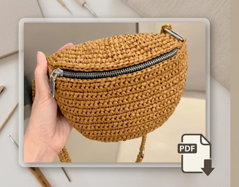 May include: A woven, tan-colored fanny pack with a black zipper and silver zipper pull. The bag is held by a hand and has a strap. The bag is made of a woven material and has a rounded shape. The bag is a PDF download.