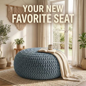 May include: A round, blue, chunky knit pouf ottoman featuring a textured, crocheted surface. An open book and a beige ceramic mug rest on top, with a cream-colored throw blanket draped over the side. The text reads: YOUR NEW FAVORITE SEAT.
