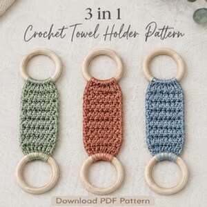 May include: Three crochet towel holders with light wood rings and textured yarn centers in sage green, terracotta, and dusty blue. The text 3 in 1 Crochet Towel Holder Pattern and Download PDF Pattern is visible above and below the items.