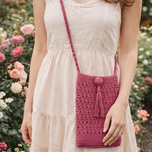 Puede incluir: Bolso bandolera de ganchillo hecho a mano en color rosa intenso. El bolso presenta un patrón de puntadas texturizadas, una borla y una correa trenzada. El bolso mide aproximadamente 20 cm de alto y 13 cm de ancho, ideal para lo esencial.