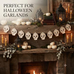 May include: A cream-colored crochet garland featuring eleven skull-shaped motifs strung along a thin twine cord. The text "PERFECT FOR HALLOWEEN GARLANDS" is visible in the upper left corner of the image, displayed in a dark serif font.
