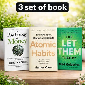 May include: Three hardcover books are displayed, with titles including "The Psychology of Money," "Atomic Habits," and "The Let Them Theory." The books are on a wooden surface, with green foliage in the background. The text "3 set of book" is at the top.