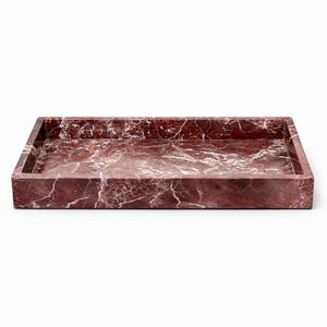 Pode incluir: Uma bandeja retangular feita de mármore vermelho com veios brancos. A bandeja tem uma borda elevada e um acabamento polido. Esta bandeja decorativa é adequada para servir ou exibir itens.