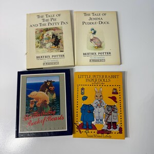 May include: Four books including The Tale of The Pie and The Patty Pan, The Tale of Jemima Puddle-Duck, The Bathing Book of Beasts, and Little Peter Rabbit Paper Dolls in Full Color, featuring various illustrations of animals and characters.