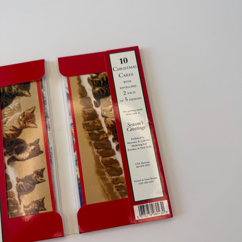 May include: A pack of 10 Christmas cards with envelopes, featuring 2 each of 5 designs. The packaging is red with a gold-toned panel displaying illustrations of various kittens. Text on the front includes 10 Christmas Cards, Season's Greetings, and publisher details.
