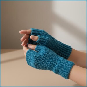May include: Teal blue fingerless gloves. The gloves are knitted with a ribbed texture and cover the hand up to the knuckles, leaving the fingers free. The gloves are made of a soft, warm material.