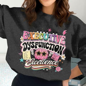 Dark sweatshirt with "Executive Dysfunction" and "Brilliant Ideas Loading" graphics.