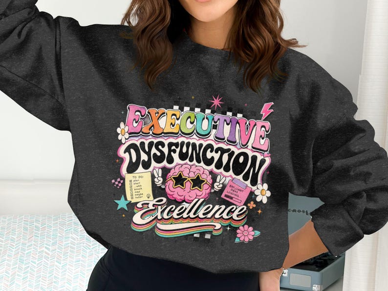 Dark sweatshirt with "Executive Dysfunction" and "Brilliant Ideas Loading" graphics.
