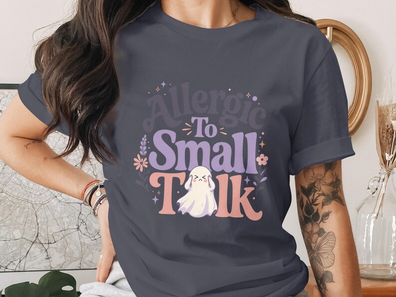 T-shirt with graphic: "Allergic To Small Talk" and a sad ghost.
