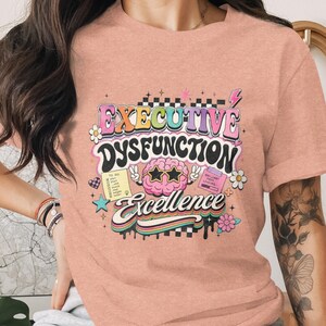 T-shirt with "Executive Dysfunction Excellence" in retro font and illustrations.