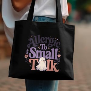 Black tote bag with "Allergic To Small Talk" text and a ghost graphic.