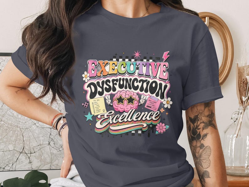 T-shirt with "Executive Dysfunction Excellence" text and colorful graphics.