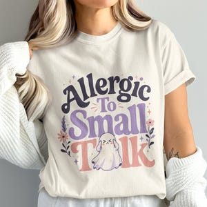 Cream t-shirt with "Allergic To Small Talk" text and ghost graphic.