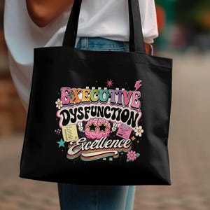 Black tote bag with "Executive Dysfunction Excellence" and to-do list.