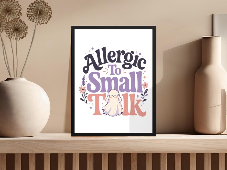 "Allergic To Small Talk" text with a ghost and floral design on a framed print.