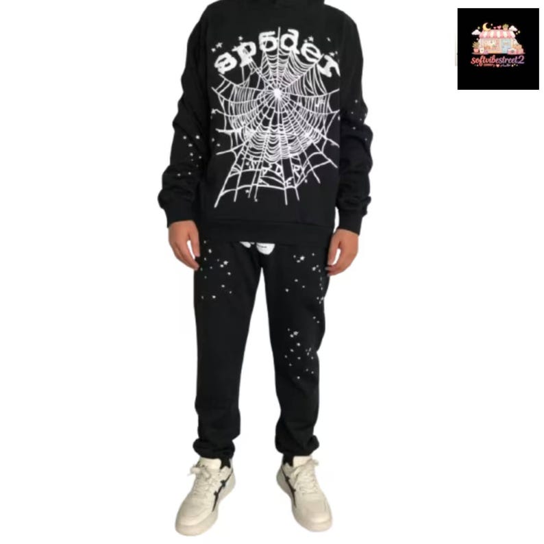 May include: Black hoodie and sweatpants set with a white spider web design and the word "spider" in a stylized font. The sweatpants and hoodie have white star-like accents. The set is paired with white sneakers.