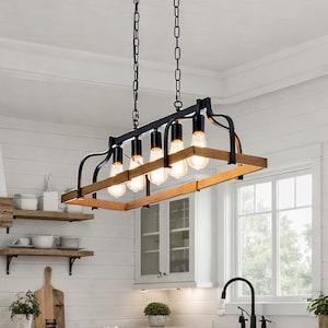 May include: A rectangular farmhouse-style chandelier with six exposed light bulbs. The fixture features a black metal frame and chain, with a natural wood border. The light hangs above a kitchen island with wooden chairs.