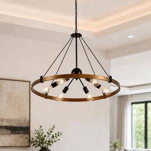 May include: A modern, circular chandelier with a black chain and frame, featuring a gold-colored ring holding multiple light bulbs. The fixture hangs from the ceiling, illuminating a dining area with neutral tones.
