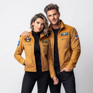 Könnte beinhalten: Zwei Personen tragen passende hellbraune Fliegerjacken über schwarzen Rollkragenpullovern und schwarzen Jeans. Die Jacken sind mit NASA- und Piloten-Aufnähern auf Brust und Ärmeln sowie einer kleinen amerikanischen Flagge am Ärmel versehen.