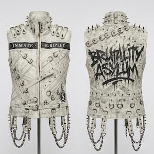 May include: A white leather vest adorned with metal studs, straps, and chains. The front has the text "INMATE R. RIPLEY" and a circular logo. The back features the words "BRUTALITY ASYLUM" in a graffiti-style font.