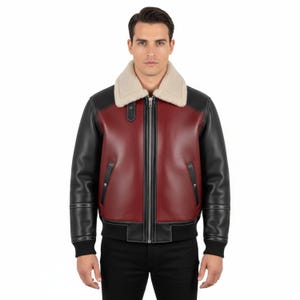 Puede incluir: Chaqueta bomber de cuero burdeos y negro con cuello de borrego crema. La chaqueta tiene cremallera, puños de canalé negros y dos bolsillos delanteros. Estilo clásico.