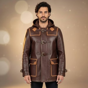 Puede incluir: Un abrigo tipo duffle de cuero marrón con capucha y cierres de palanca. El abrigo presenta detalles en color beige en la capucha, los bolsillos y los ribetes. El abrigo tiene un diseño clásico y es adecuado para el clima frío. El abrigo tiene una longitud de aproximadamente 91 cm.