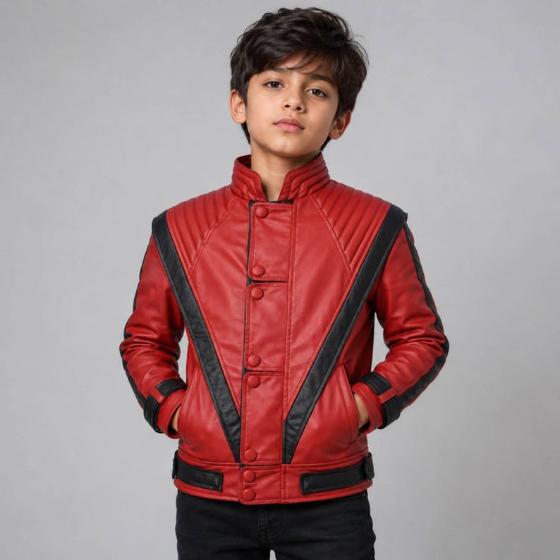 May include: A red jacket with black accents, featuring a high collar, vertical quilted shoulder panels, and a front button closure. The design includes black stripes running diagonally from the shoulders to the waist and black trim at the cuffs.