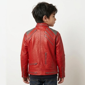 May include: A bright red jacket featuring a stand-up collar, long sleeves, and multiple silver-toned metal zippers placed diagonally and vertically across the back and shoulders. The upper back panel has a textured grey fabric detail.