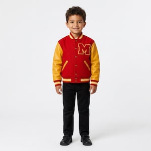 May include: A varsity jacket featuring a red wool-blend body, yellow leather sleeves, and a large yellow letter M on the chest. The jacket has a snap-button front closure, striped ribbed cuffs, a striped collar, and two side pockets with yellow trim.