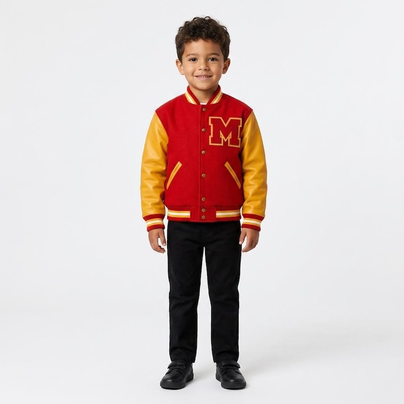 May include: A varsity jacket featuring a red wool-blend body, yellow leather sleeves, and a large yellow letter M on the chest. The jacket has a snap-button front closure, striped ribbed cuffs, a striped collar, and two side pockets with yellow trim.