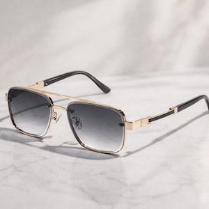 May include: A white ceramic mug with a black handle and the text "But First, Coffee" in a bold, black font. The mug is set against a blurred background, suggesting a cosy setting.