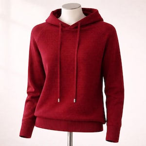 Op de afbeelding: Een dieprode hoodie met een capuchon met trekkoord en geribde manchetten en zoom. De sweatshirt met lange mouwen wordt op een mannequin getoond. De merknaam "Chloe's boutique by Joy" is zichtbaar.