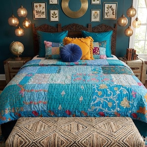 Puede incluir: Una habitación con una cama con un edredón patchwork en tonos azules y turquesas. Cojines decorativos en verde azulado, amarillo y azul adornan la cama. Un banco tejido se encuentra al pie de la cama y lámparas de globo cuelgan del techo.