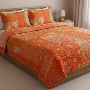 May include: An orange patchwork quilt and two matching pillowcases on a wooden bed frame. The quilt features a variety of orange hues and floral embroidery. The bed is made up and ready for use.