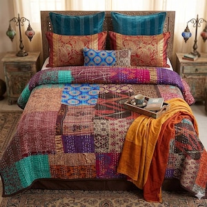 May include: A bed with a patchwork quilt in shades of burgundy, teal, purple, and gold. The bed is adorned with decorative pillows in teal and red paisley patterns. A wooden tray with a cup and book rests on the quilt.